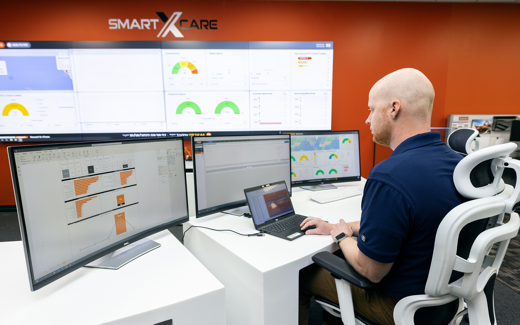 A DEVELON telematics manager looks at equipment data on a screen