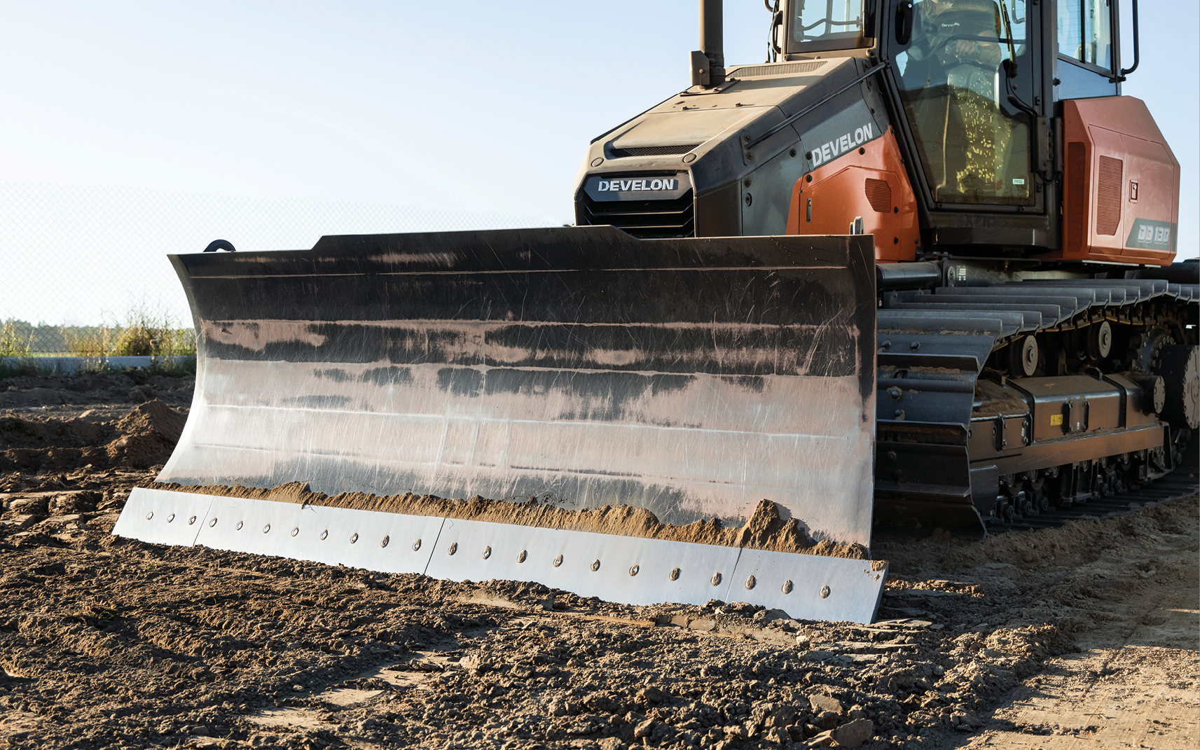 A DEVELON dozer paired with a large dozer blade.